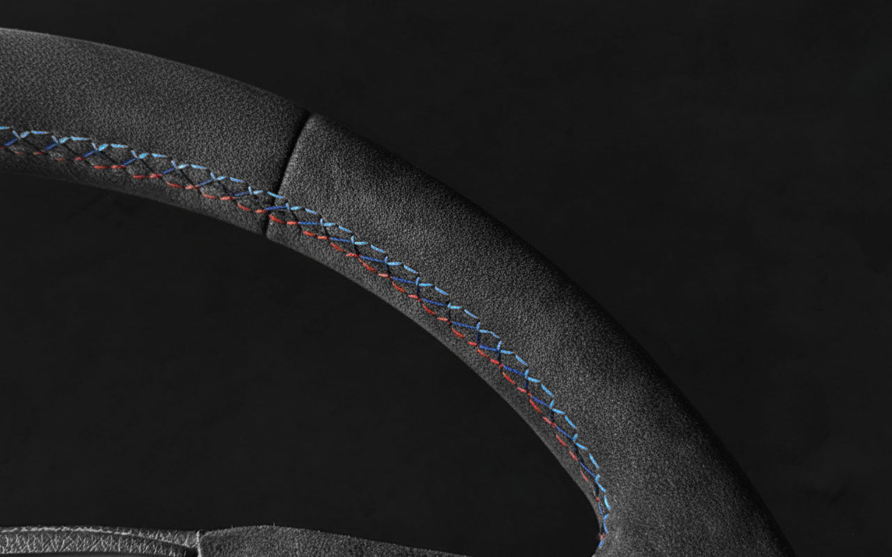 Macro shot of BMW 1 & 2 Series Alcantara Steering Wheel – Tricolor Stitching (F21, F22, F23)